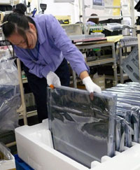 The assembly process begins with the LCD panel. LCD panels arrive from our suppliers wrapped in plastic sacks and stored inside Styrofoam containers. Once ready for assembly, they are removed from their bags and placed face up on pink protective cushions.