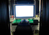 Once assembly is complete, each monitor undergoes an initial screen check inside of an image inspection apparatus. Inside black curtains, a CCD camera automatically determines if the monitor is displaying an image correctly.